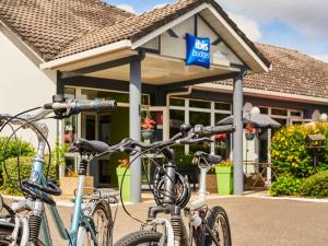 um grupo de bicicletas estacionadas em frente a uma loja em Ibis Budget Versailles Coignieres em Coignières