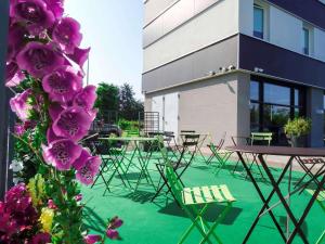 a group of tables and chairs in front of a building at ibis budget Tours Nord in Tours