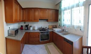 a kitchen with wooden cabinets and a sink and a microwave at House of Aggelos - Karya Lefkadas in Kariá
