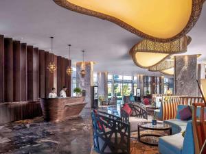 a lobby of a hotel with people sitting at a bar at Pullman Phu Quoc Beach Resort in Phú Quốc