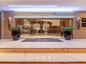 un grand magasin de mercure avec deux plantes en pot à la fenêtre dans l'établissement Grand Mercure Curitiba Rayon, à Curitiba