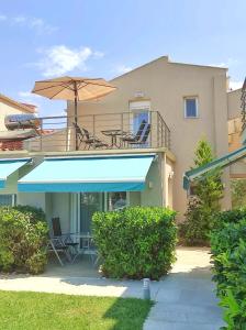 a house with a patio with a table and an umbrella at Yalos Beach Maisonettes in Skala Sotiros