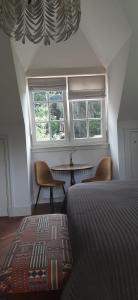 a bedroom with a bed and a table and windows at Huize Koempoelan in Naarden