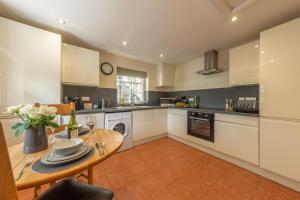 a kitchen with a wooden table and a dining room at White Rose Cottage in Constable Burton +14 photos