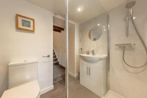 a bathroom with a shower and a toilet and a sink at White Rose Cottage in Constable Burton