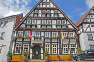 um edifício em enxaimel com flores à frente em WIRTSHAUS am Niederntor em Blomberg