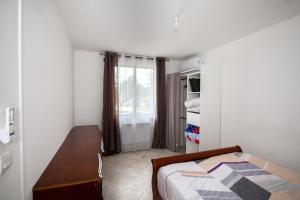a bedroom with a bed and a desk and a window at Appartement 3pieces in Pierrelaye