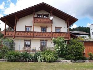 a large white house with a wooden roof at Ferienwohnung Haus am Berg in Innernzell