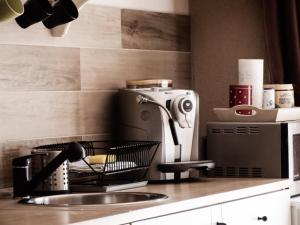 a kitchen counter with a sink and a microwave at Orchidea Apartman in Csopak