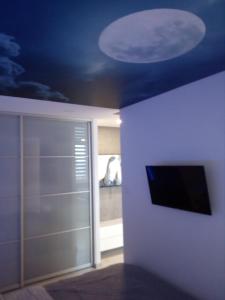 um quarto com um tecto azul e uma televisão na parede em Słoneczne Planty em Zamość