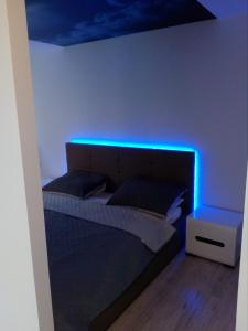 a bedroom with a bed with a blue light at Słoneczne Planty in Zamość