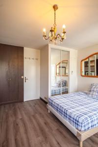 a bedroom with a bed and a chandelier at Grand Appartement de 3 pièces in Pierrelaye