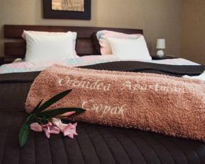 a bed with a blanket that says controlled guest comfort at Orchidea Apartman in Csopak