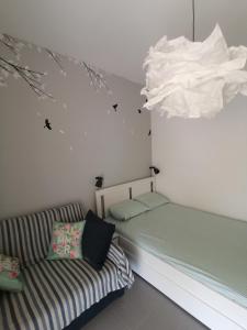 Habitación con cama, sofá y lámpara de araña. en Elef Apartment, en Paralia Dionisiou