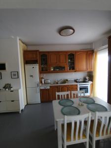 cocina con mesa, sillas y nevera blanca en Elef Apartment, en Paralia Dionisiou