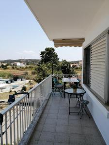 un patio con mesas y sillas en el balcón en Elef Apartment, en Paralia Dionisiou