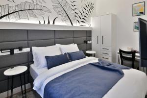 a bedroom with a large bed with blue pillows at Luxury Galla Apartments in the City Center in Sarajevo