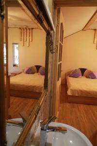 łazienka z 2 łóżkami, umywalką i lustrem w obiekcie namelis nr 2 Adelės sodyba w mieście Muižė