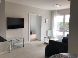 a living room with a couch and a tv on a wall at Apartament De Lux Apart 45 Grabiszyńska in Wrocław