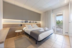a bedroom with a large bed and a large window at Apartaments Terraza - Santa Maria in Roses