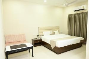 a bedroom with a bed and a chair at The Eden in Indore