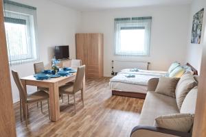 een woonkamer met een tafel en een bed bij Thermal Apartman - FSZ in Gárdony