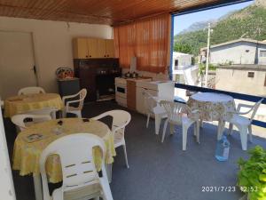 a room with tables and chairs and a kitchen at Guest House - Marija Delija in Sutomore