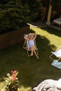 a woman in a bikini sitting on a lawn chair at Hotel Goldener Ochs in Bad Ischl