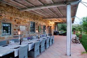 an outdoor dining room with a long table and chairs at Podere Marcigliano in Badia A Passignano