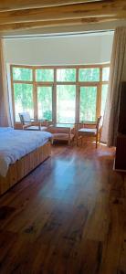 a bedroom with a bed and some windows at Zee Guest House in Leh