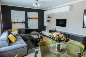 a living room with a couch and a table at Charlotte Apartment - 2Bedrooms w Parking near Nymphaea in Oradea