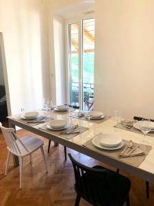 a table with chairs and plates and glasses on it at Apartment Porto Poreč in Poreč