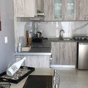 uma cozinha com armários de madeira e um frigorífico de aço inoxidável em V&D Paleokastritsa Apartments em Lákones