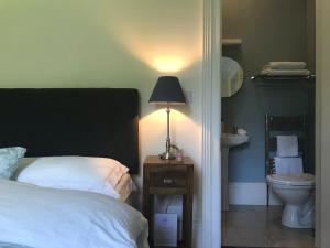 1 dormitorio con cama y mesita de noche con lámpara en Blackhill Woods Retreat, en Abbeyleix