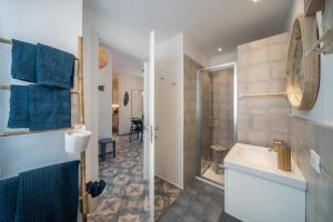 a bathroom with a sink and a shower with blue towels at Casa Royale Appartamento Acqua in Lierna +16 photos