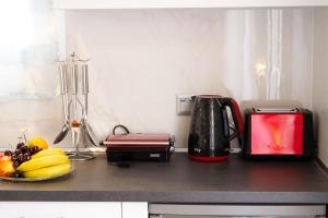 a kitchen counter with a toaster and a plate of fruit at ANTONIS APARTMENTS in Kassiopi