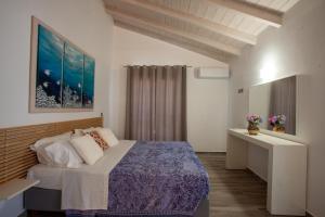 a bedroom with a bed and a painting on the wall at ANTONIS APARTMENTS in Kassiopi