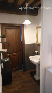 a bathroom with a sink and a wooden door at Residence Garibaldi bilocale e monolocale in centro a Foligno terzo e quarto piano in Foligno