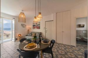 jadalnia i salon ze stołem i krzesłami w obiekcie Casa Royale Appartamento Acqua w mieście Lierna