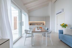a kitchen and dining room with a table and chairs at Pareus Beach Resort in Caorle