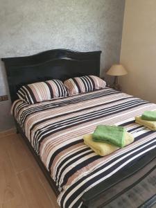 1 cama grande con sábanas a rayas y almohadas en RIAD ANIS, en Essaouira