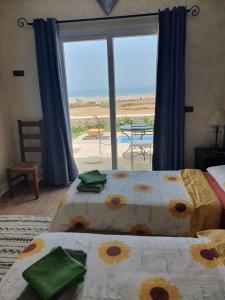2 camas en una habitación con vistas al océano en RIAD ANIS, en Essaouira