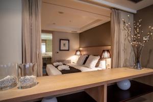 ein Schlafzimmer mit einem Bett und einem Tisch mit Blumen darin in der Unterkunft Washington Parquesol Suites & Hotel in Valladolid