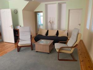 a living room with a couch and two chairs at Family Apartments in Jūrmala