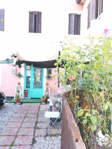 a garden in front of a house with a blue door at Art B&B La Casa del Pittore in Revine Lago