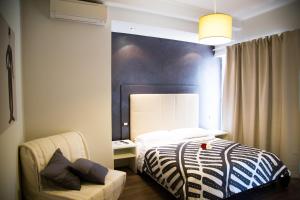 um quarto com uma cama e uma cadeira em Modern BnB em Roma
