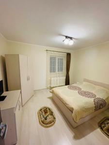 a bedroom with a bed and a window at Apartament ExtraLarge in Buşteni