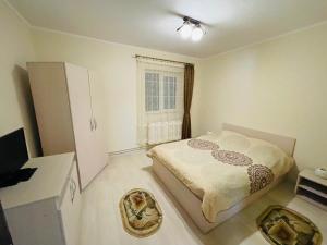 a small bedroom with a bed and a window at Apartament ExtraLarge in Buşteni