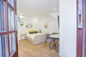 Schlafzimmer mit einem Bett und einem Tisch mit Stühlen in der Unterkunft Liceiras Apartments By Guestify in Porto