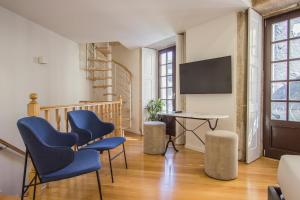 ein Wohnzimmer mit 2 blauen Stühlen und einem Schreibtisch in der Unterkunft Liceiras Apartments By Guestify in Porto
